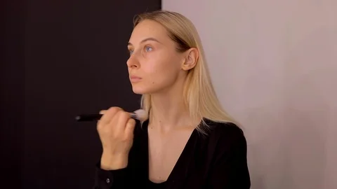 Young caucasian model applying professional makeup. beautiful woman applying Stock Footage 113856218
