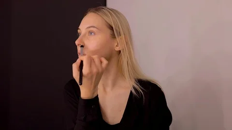 Young caucasian model applying professional makeup. beautiful woman applying Stock-Footage 113856616