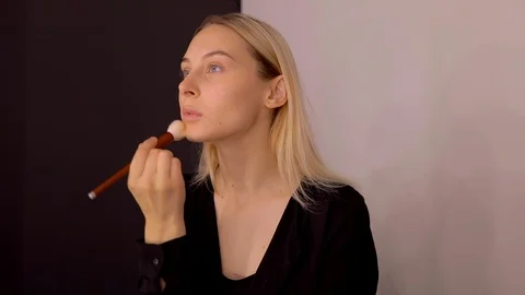Young caucasian model applying professional makeup. beautiful woman applying Stock Footage 113856965
