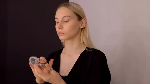 Young caucasian model applying professional makeup. beautiful woman applying Stock Footage 113865047