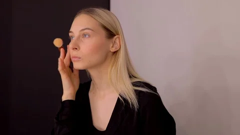Young caucasian model applying professional makeup. beautiful woman applying Stock Footage 113865129
