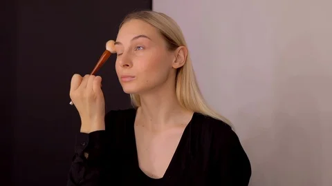 Young caucasian model applying professional makeup. beautiful woman applying Stock Footage 113865281
