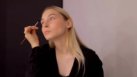 Young caucasian model applying professional makeup. beautiful woman applying Stock Footage 113865410