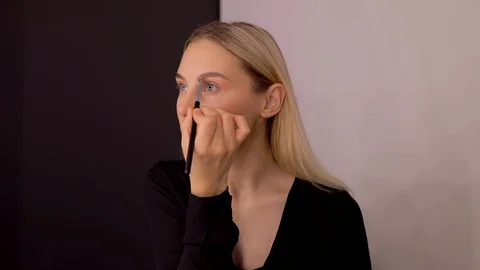 Young caucasian model applying professional makeup. beautiful woman applying Stock Footage 113865566