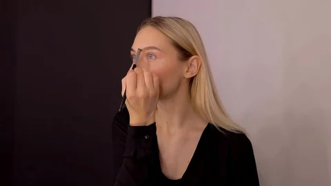 Young caucasian model applying professional makeup. beautiful woman applying Stock Footage 113865638