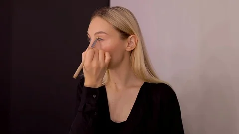 Young caucasian model applying professional makeup. beautiful woman applying Stock Footage 113867066