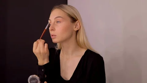 Young caucasian model applying professional makeup. beautiful woman applying Stock Footage 113867217