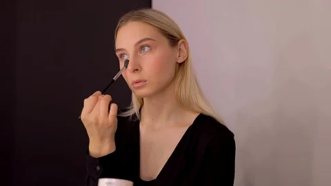 Young caucasian model applying professional makeup. beautiful woman applying Stock Footage 113867816