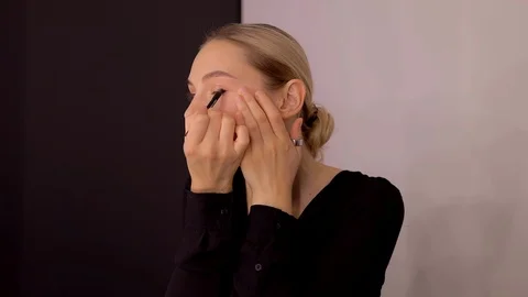 Young caucasian model applying professional makeup. beautiful woman applying Stock Footage 113868047