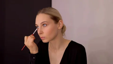 Young caucasian model applying professional makeup. beautiful woman applying Stock Footage 113868984