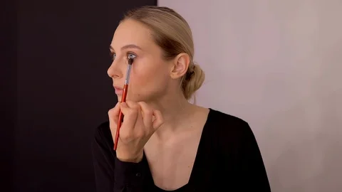 Young caucasian model applying professional makeup. beautiful woman applying Stock Footage 113869024