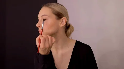 Young caucasian model applying professional makeup. beautiful woman applying Stock Footage 113869111