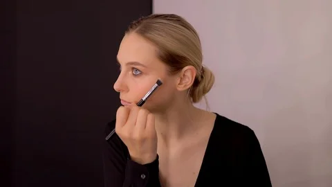 Young caucasian model applying professional makeup. beautiful woman applying Stock Footage 113912863