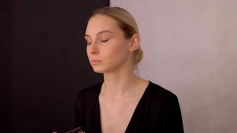 Young caucasian model applying professional makeup. beautiful woman applying Stock Footage 113913097