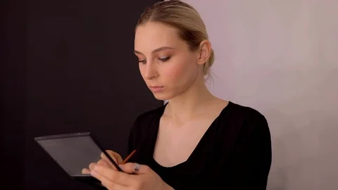Young caucasian model applying professional makeup. beautiful woman applying Stock Footage 113913258