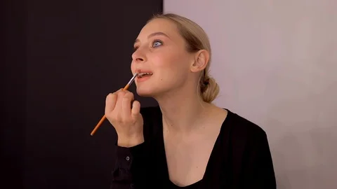 Young caucasian model applying professional makeup. beautiful woman applying Stock Footage 113913364