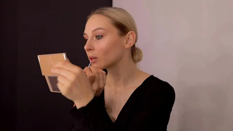 Young caucasian model applying professional makeup. beautiful woman applying Stock Footage 113914833