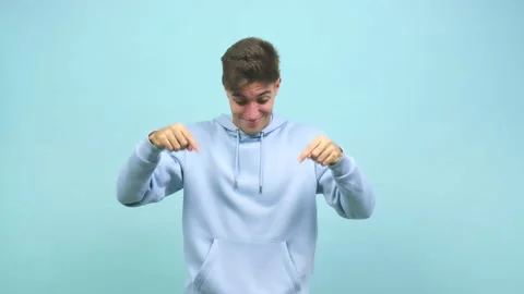Young caucasian student man pointing down, smiling surprised presenting Stock-Footage 138700278