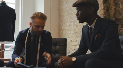 Young Caucasian Tailor Talking to Young Black Customer in Men's Fashion Shop Video stock 62554945