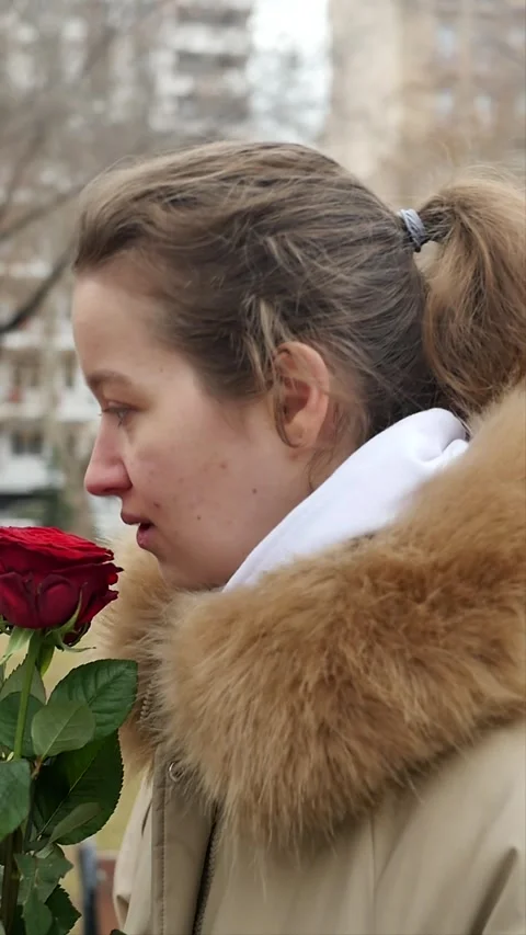 Young Caucasian woman with allergies sneezes after smelling flowers. A cute girl Stock Footage 261707650