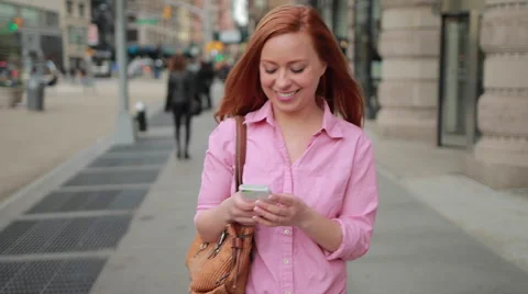 Young caucasian woman in city walking texting cell phone Stock Footage