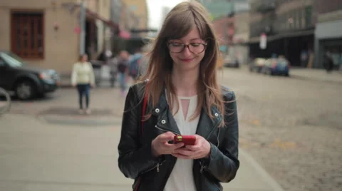 Young caucasian woman in city walking texting cell phone slow motion Stock Footage