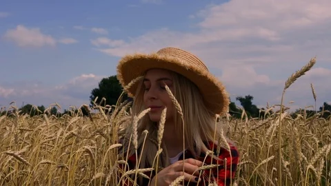 Young caucasian woman in hat sit in wheat. Close up girl on nature village Stock Footage