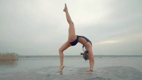 Young caucasian woman in swimsuit practicing yoga in water liman, lake or river Stock Footage