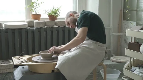 Young ceramist is working at rotating machine in pottery workshop. Stock Footage 90130999