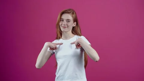 The young charismatic, confident redhead, points both fingers at her and says Stock Footage 153871777