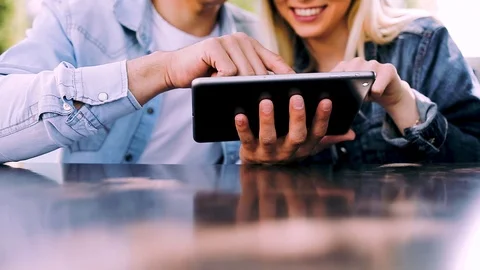 Young charming couple using tablet while sitting side by side Stock Footage 89826423