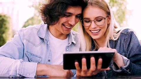 Young charming couple using tablet while sitting side by side Stock Footage 89826624