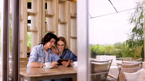 Young Charming Couple Using Tablet While Sitting Together And Drinking Coffee Stock Footage 89828564