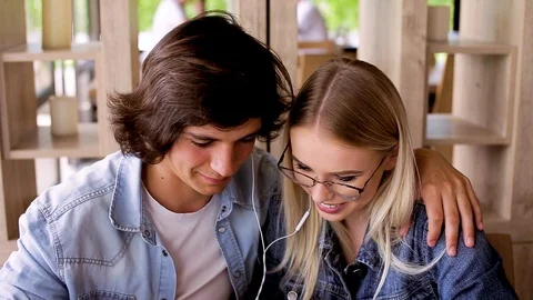 Young Charming Couple Using Tablet Listen To Music And Drinking Coffee Video stock 89828742