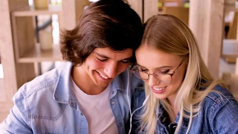 Young Charming Couple Using Tablet Listen To Music And Drinking Coffee Video stock 89829016