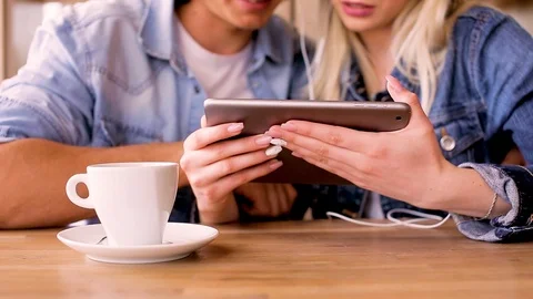 Young Charming Couple Using Tablet While Sitting Together And Drinking Coffee Video stock 89829027