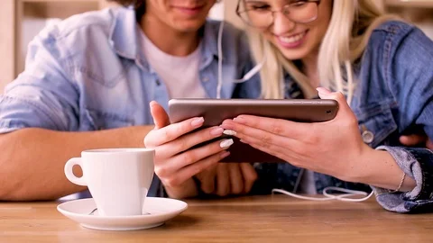 Young Charming Couple Using Tablet While Sitting Together And Drinking Coffee Video stock 89829030