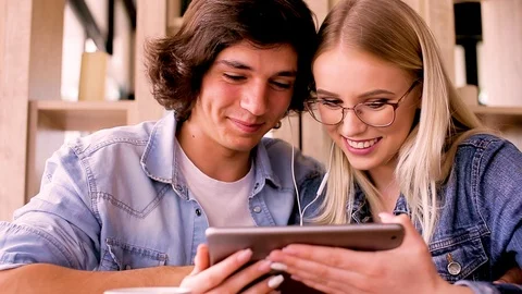 Young Charming Couple Using Tablet While Sitting Together And Drinking Coffee Stock Footage 89829095