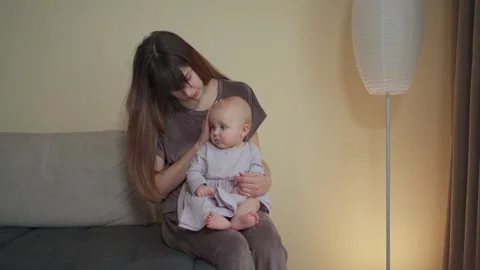 A young charming mother spends time with her cute daughter in a purple dress Vidéo 237029117