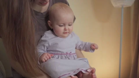 A young charming mother spends time with her cute daughter in a purple dress Vídeo Stock 237029127