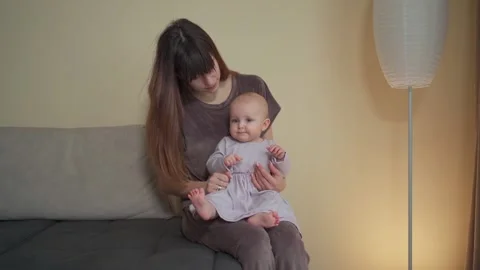 A young charming mother spends time with her cute daughter in a purple dress Vidéo 237029132