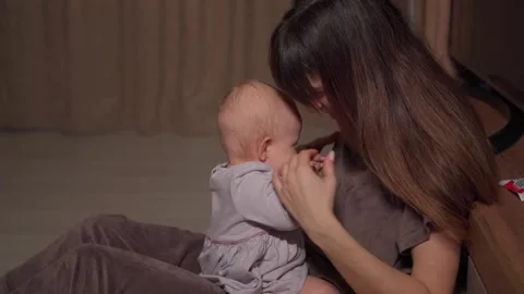 A young charming mother spends time with her cute daughter in a purple dress Vidéo 237029144