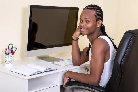 Young cheerful black man at computer Stock-Fotos
