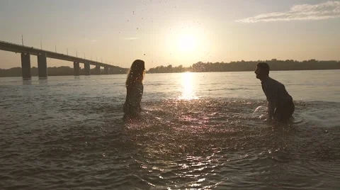 Young cheerful couple having fun in the water on a hot summer evening Stock-Footage 68060207