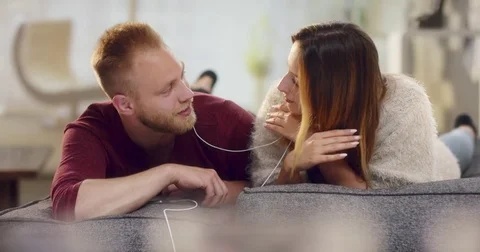 Young cheerful couple having fun while listening to some funky music Stock-Footage 77411206