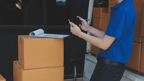 Young cheerful delivery man with parcel near car full of cardboard boxes, f.. Stock Footage 278839688