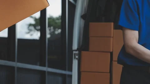 Young cheerful delivery man with parcel near car full of cardboard boxes, f.. Stock Footage 278839722