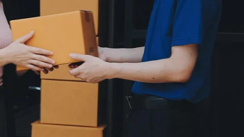 Young cheerful delivery man with parcel near car full of cardboard boxes, f.. Stock Footage 278958360