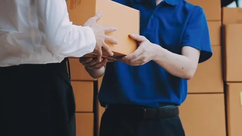 Young cheerful delivery man with parcel near car full of cardboard boxes, f.. Stock Footage 278958372