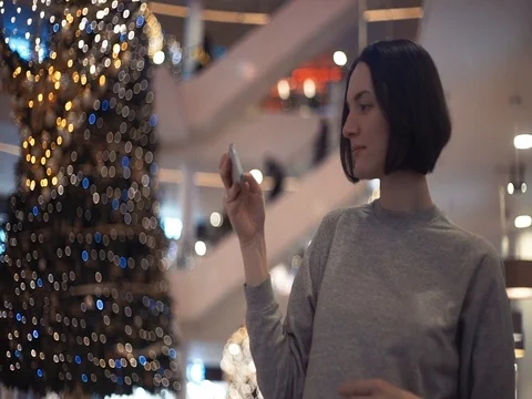 Young cheerful girl smiling using smartphone taking photo in shopping mall. Stock Footage 83366147